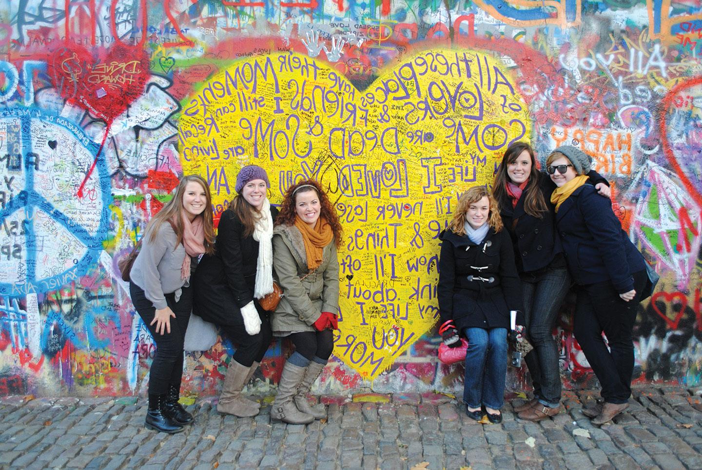 Students posing with graffiti art